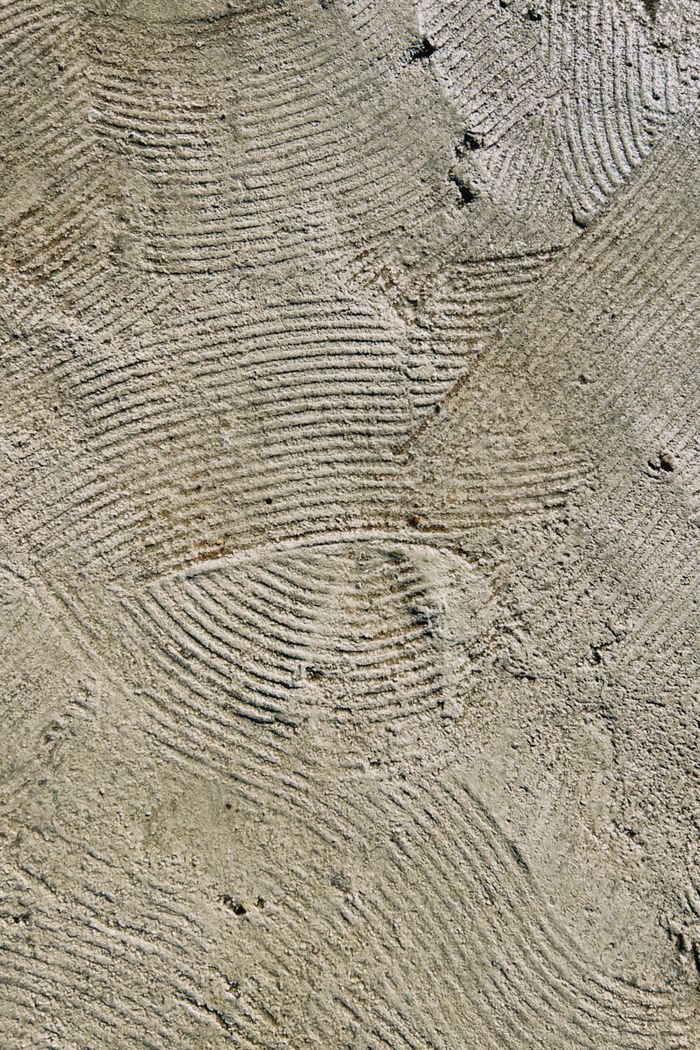 Close-up of a textured concrete surface showing intricate patterns and natural grooves.